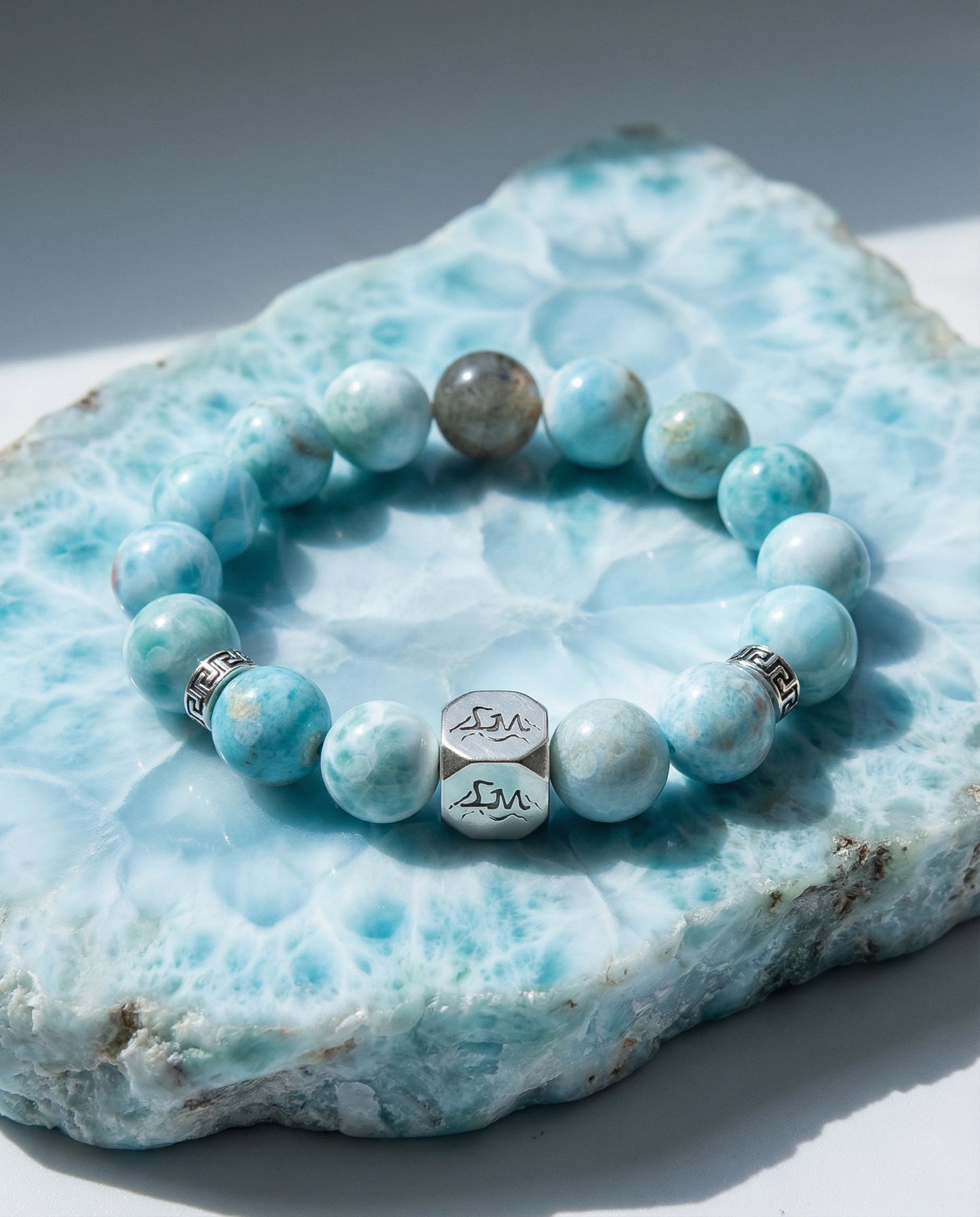 Abyss water crystal bracelet — larimar and black auralite-23 — on raw larimar mineral slab in natural light — Leymen Jewels