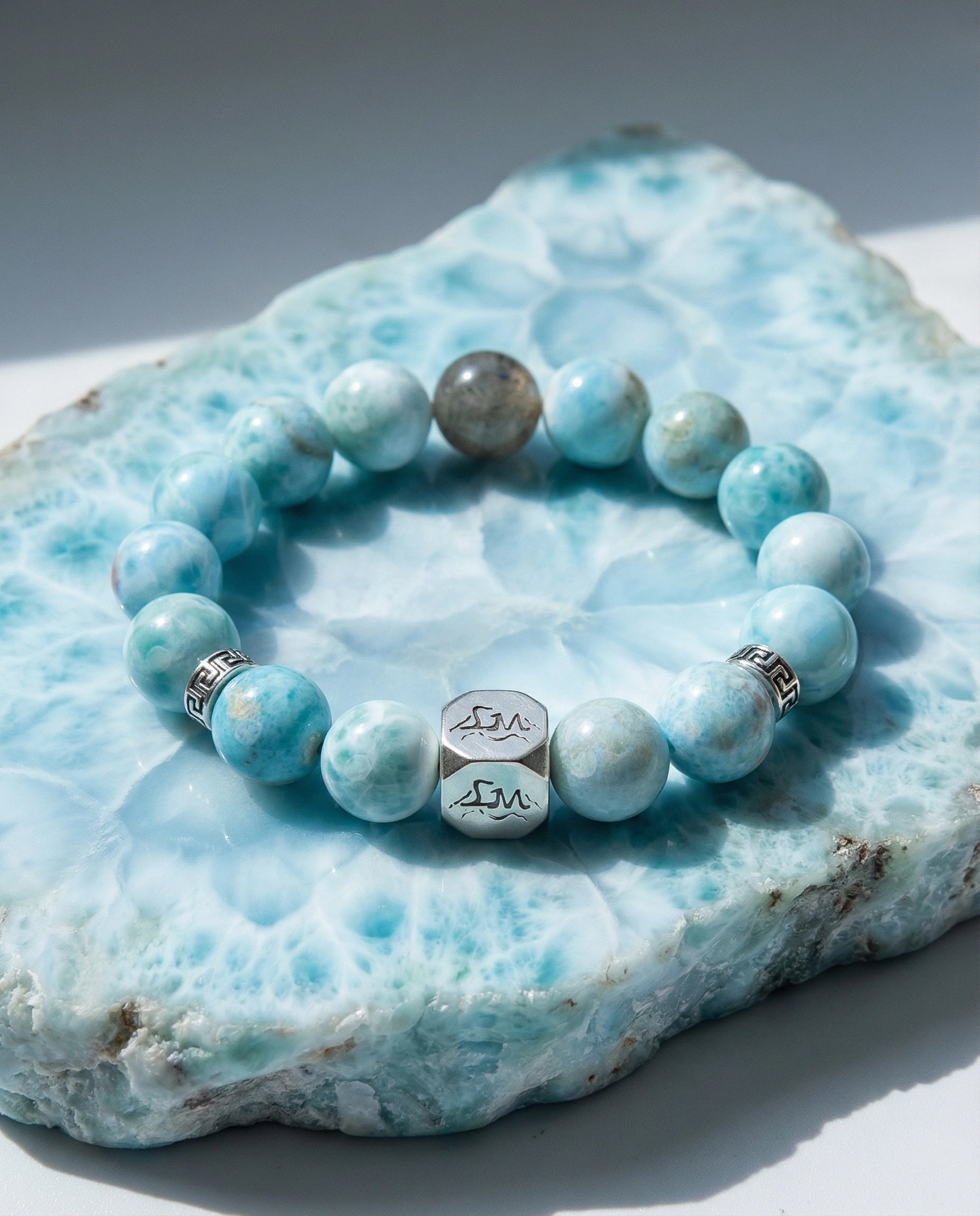 Abyss water crystal bracelet — larimar and black auralite-23 — on raw larimar mineral slab in natural light — Leymen Jewels