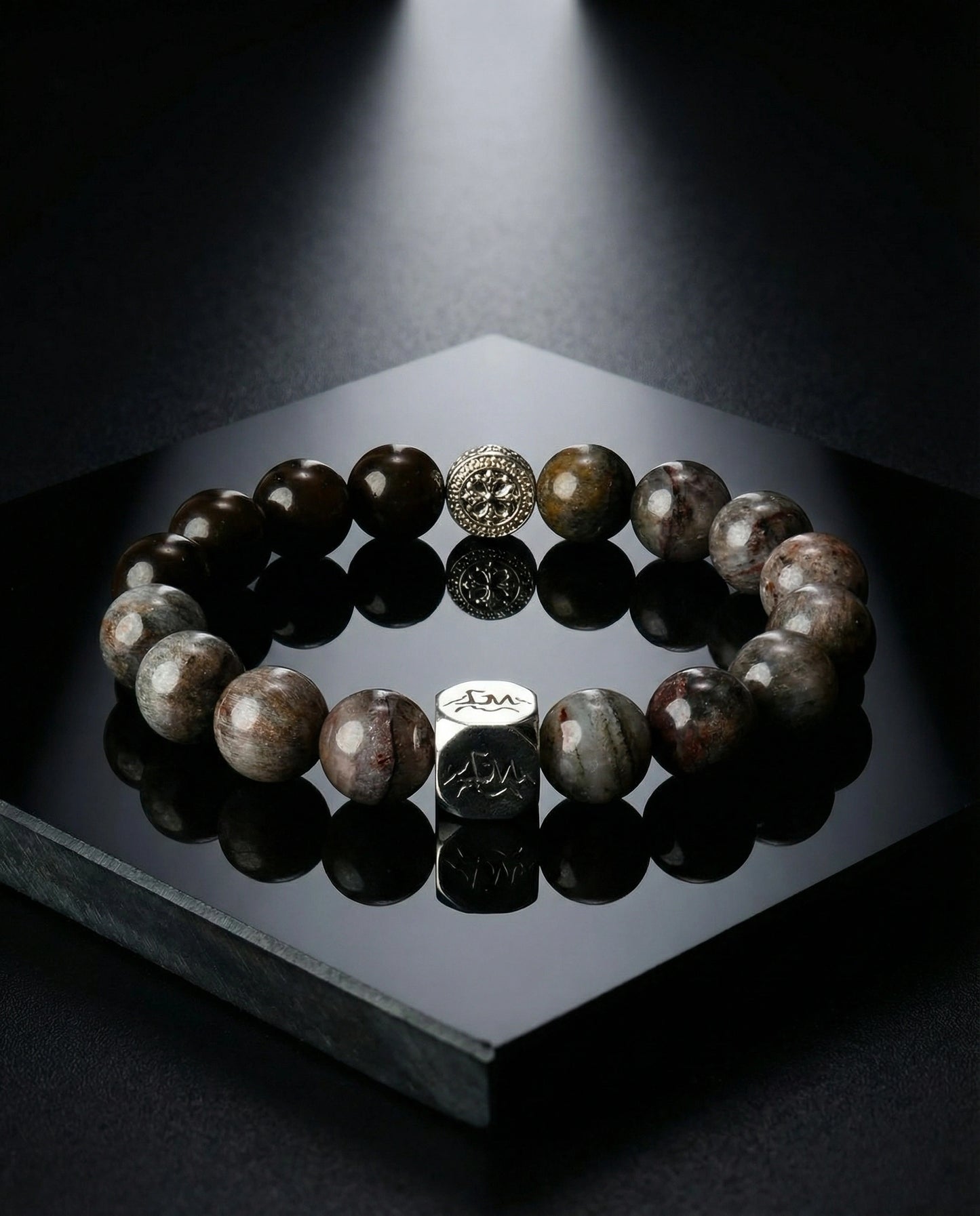 Axis metal crystal bracelet — black auralite-23 and cintamani — on black reflective stone surface with dramatic spotlight — Leymen Jewels