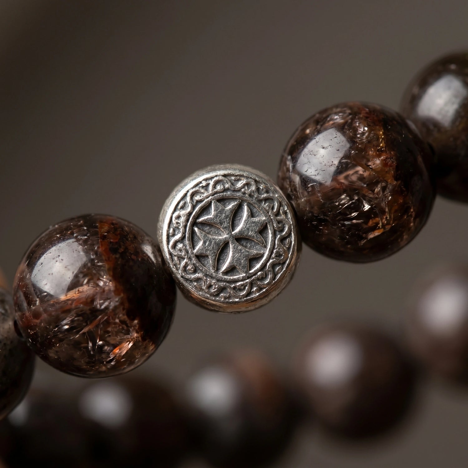 Axis metal crystal bracelet — black auralite-23 and cintamani — worn on wrist against dark slate surface — Leymen Jewels