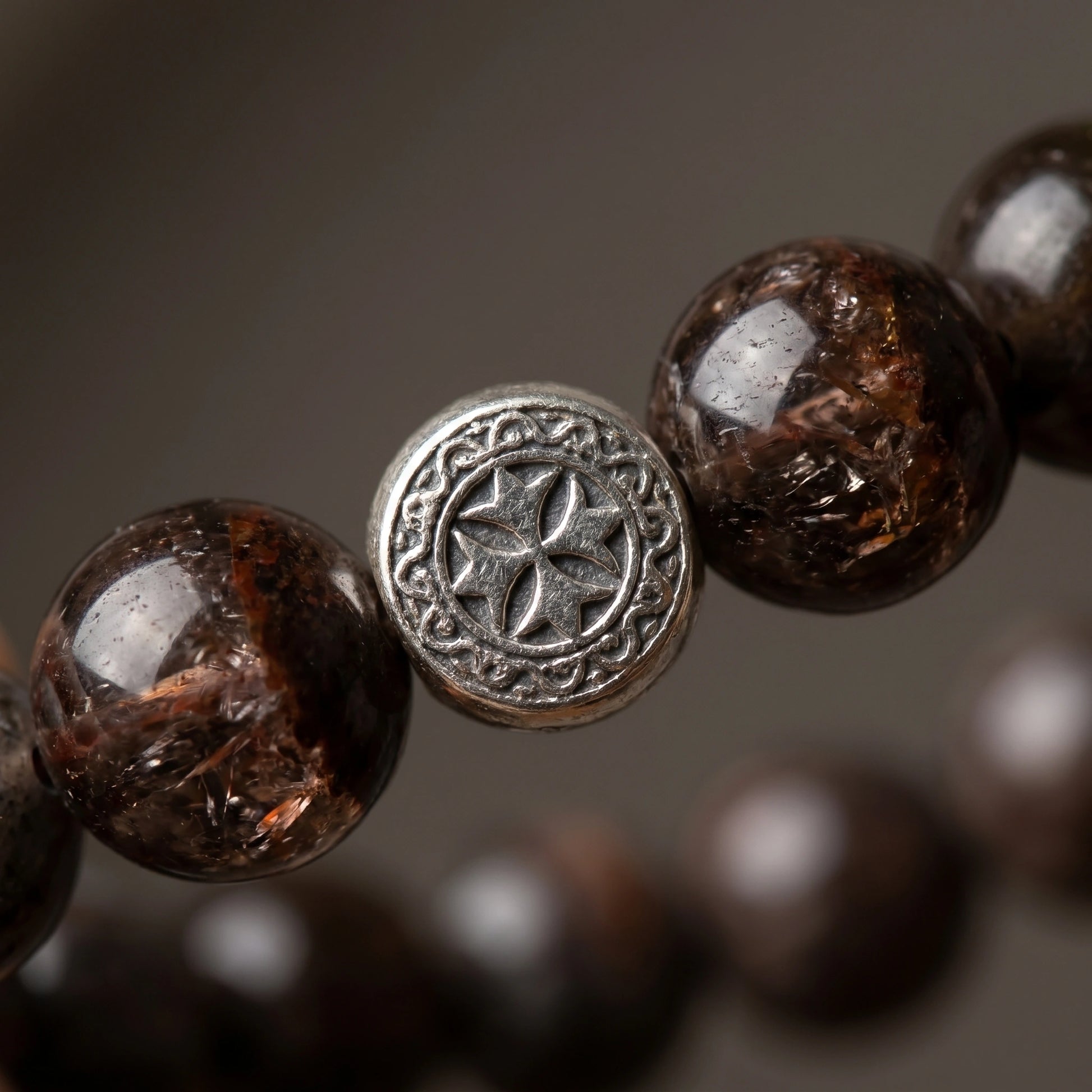 Axis metal crystal bracelet — black auralite-23 and cintamani — worn on wrist against dark slate surface — Leymen Jewels