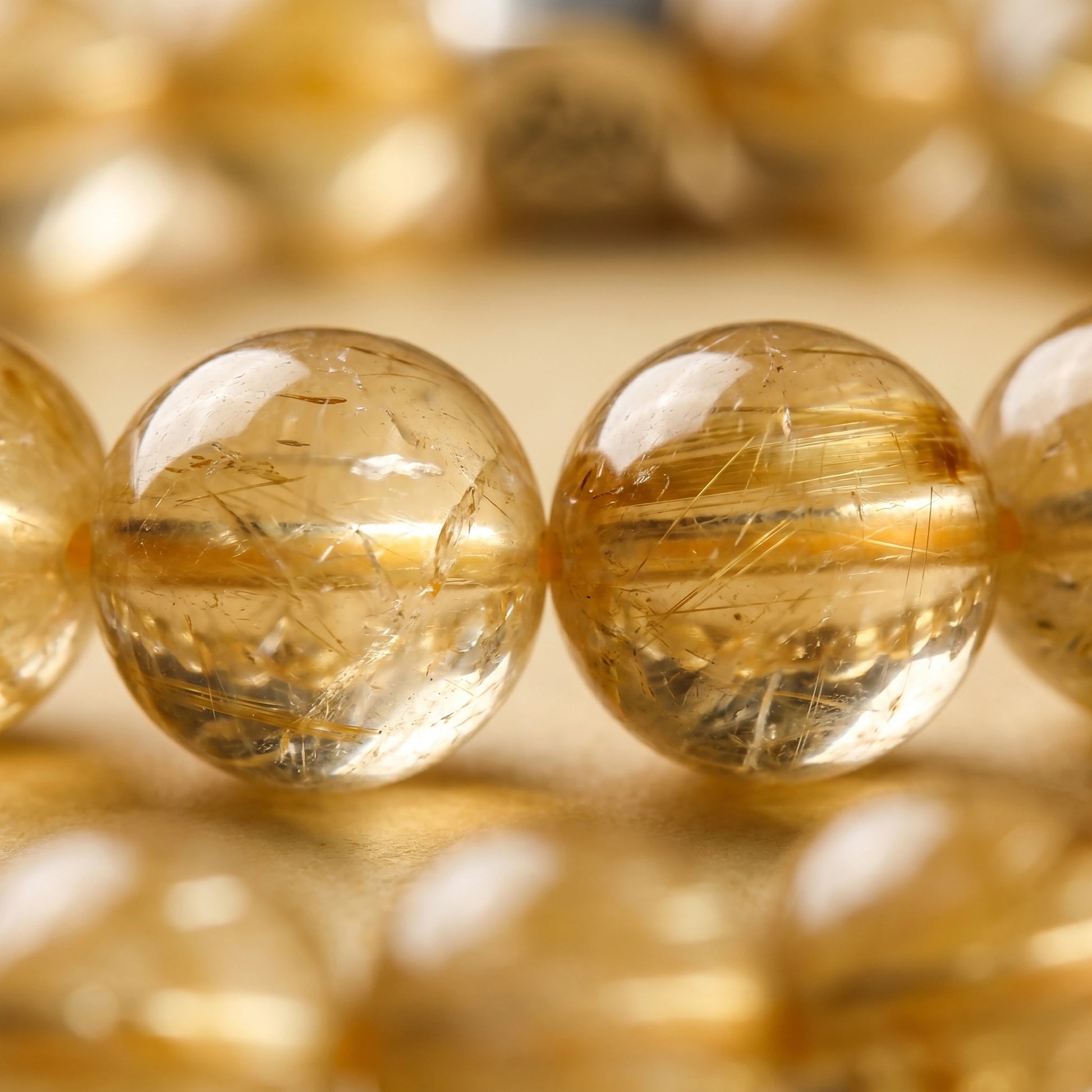 Bastion earth crystal bracelet — golden rutilated quartz macro detail showing luminous gold needle inclusions — Leymen Jewels