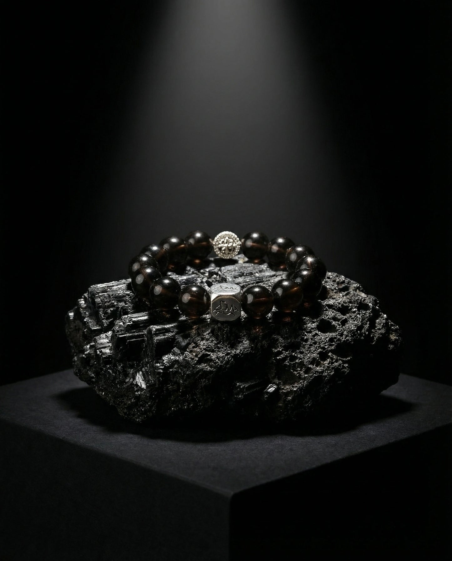 Catalyst metal crystal bracelet — cintamani — on raw black tourmaline mineral cluster under spotlight — Leymen Jewels