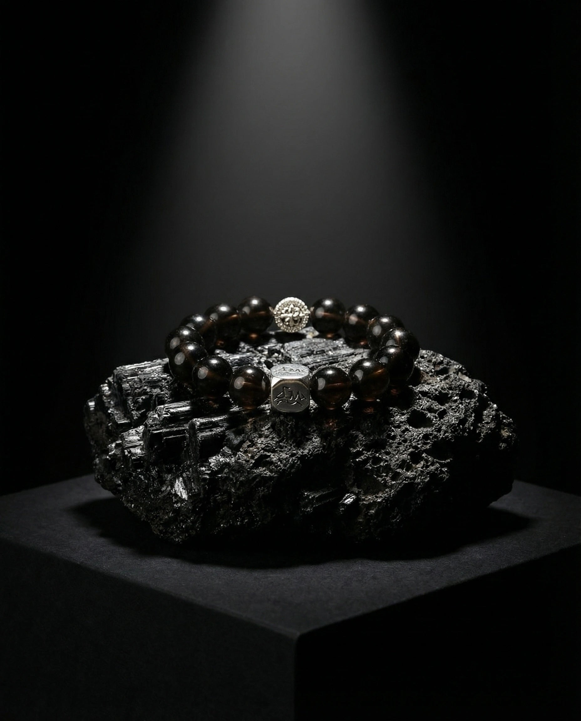 Catalyst metal crystal bracelet — cintamani — on raw black tourmaline mineral cluster under spotlight — Leymen Jewels