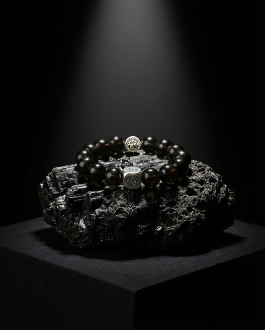 Catalyst metal crystal bracelet — cintamani — on raw black tourmaline mineral cluster under spotlight — Leymen Jewels