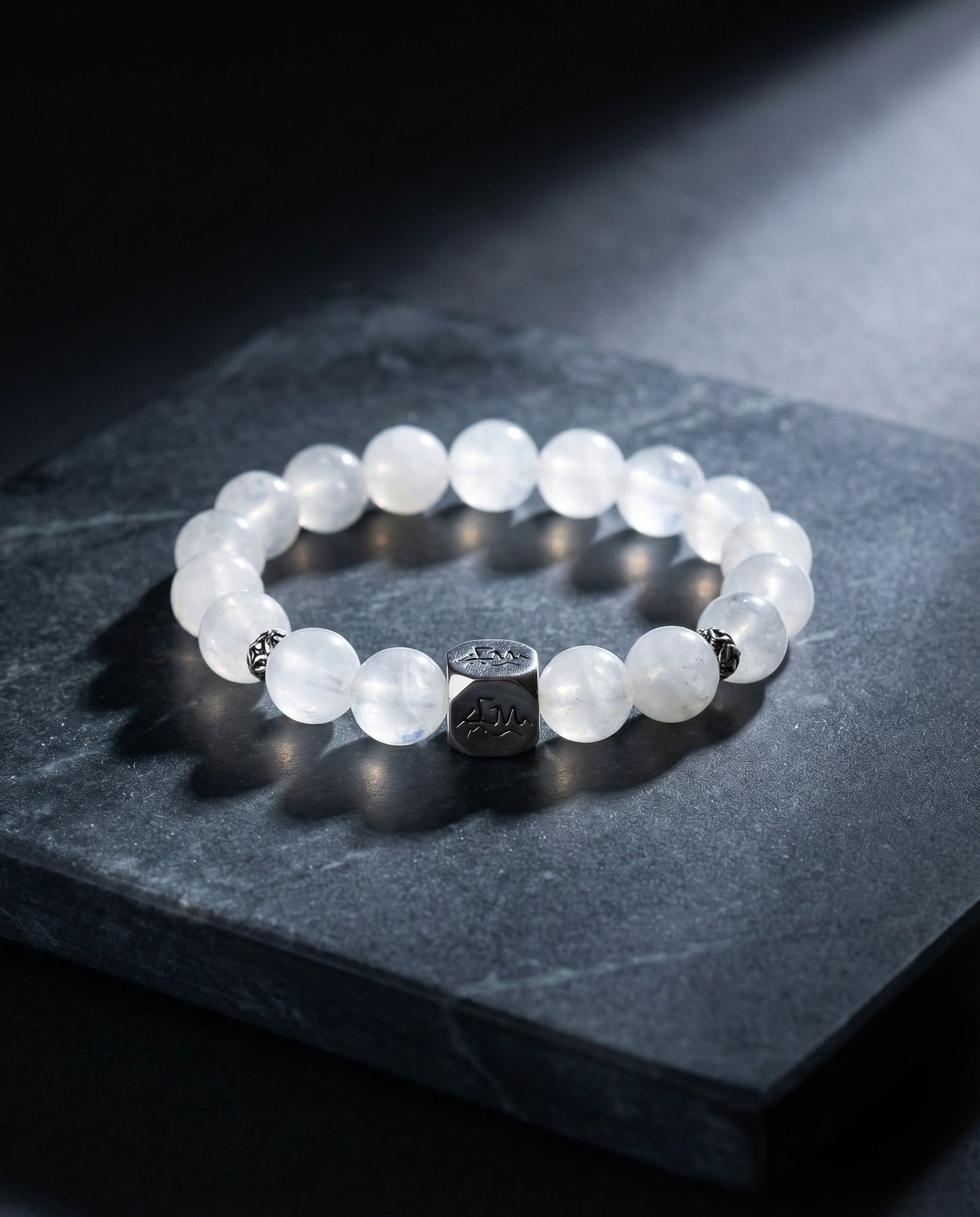 Clarity metal crystal bracelet — snow quartz and blue moonstone — on dark slate stone surface with soft light — Leymen Jewels