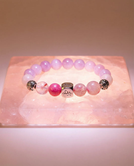 Evania fire crystal bracelet — kunzite, rhodonite, rose quartz — on raw rose quartz slab — Leymen Jewels