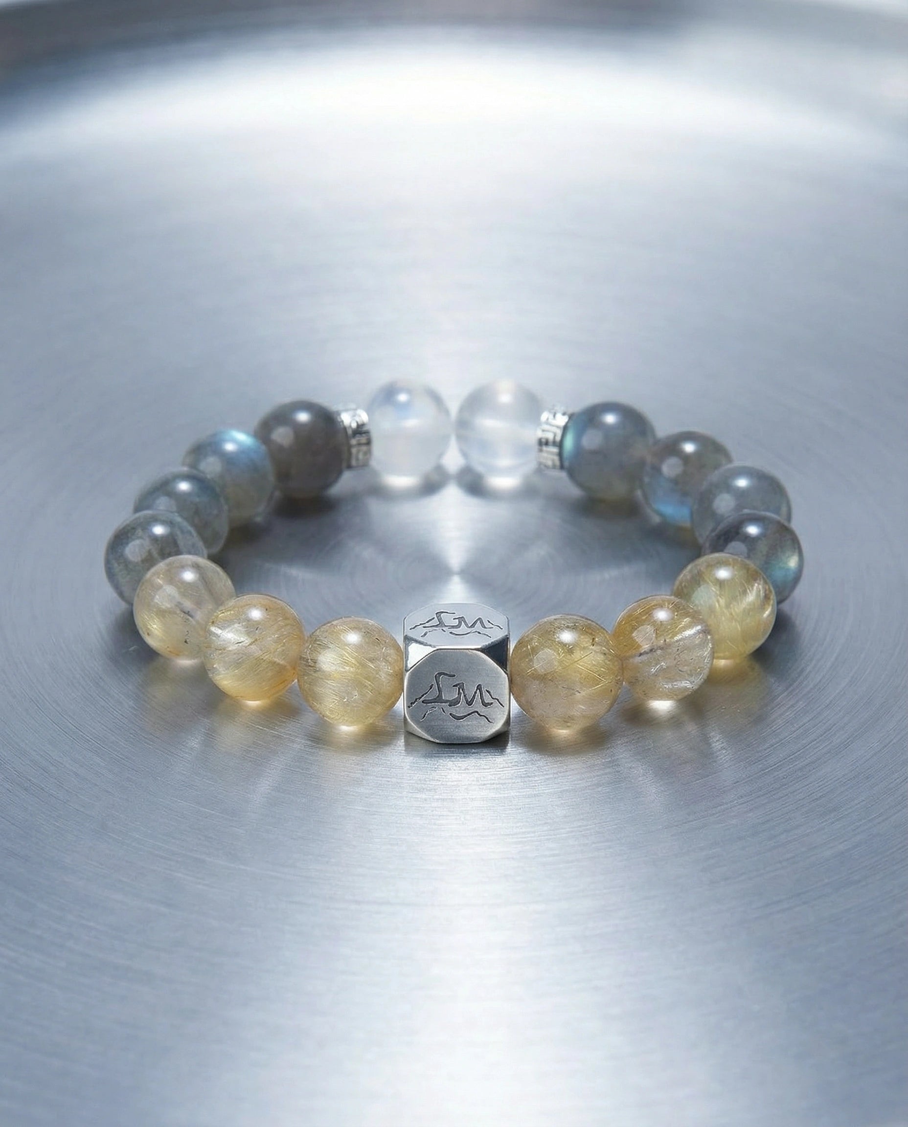 Horizon metal crystal bracelet — golden rutilated quartz and grey moonstone — on brushed steel surface — Leymen Jewels