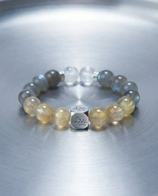 Horizon metal crystal bracelet — golden rutilated quartz and grey moonstone — on brushed steel surface — Leymen Jewels