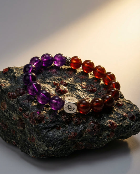 Ignis fire crystal bracelet — amethyst and orange garnet — on dark volcanic rock with warm light — Leymen Jewels