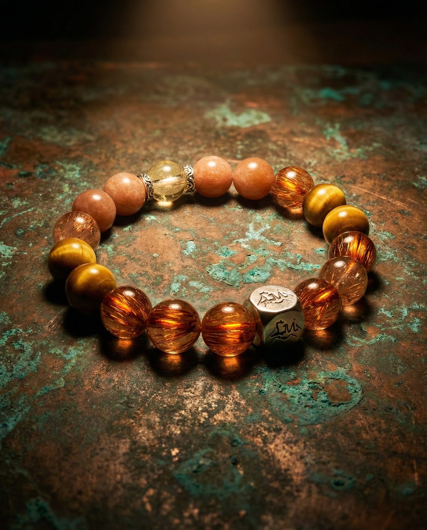 Ironflare earth crystal bracelet — copper rutilated quartz and sunstone — on aged copper surface — Leymen Jewels