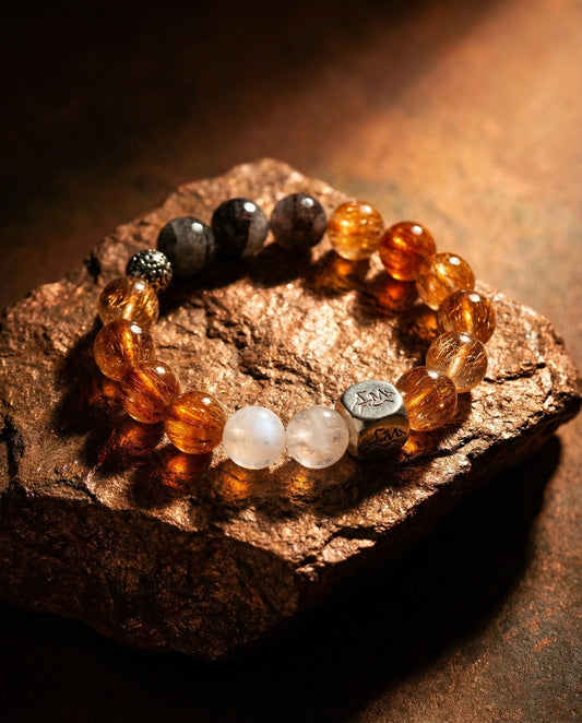 Meridian metal crystal bracelet — copper rutilated quartz and blue moonstone — on warm copper mineral rock — Leymen Jewels