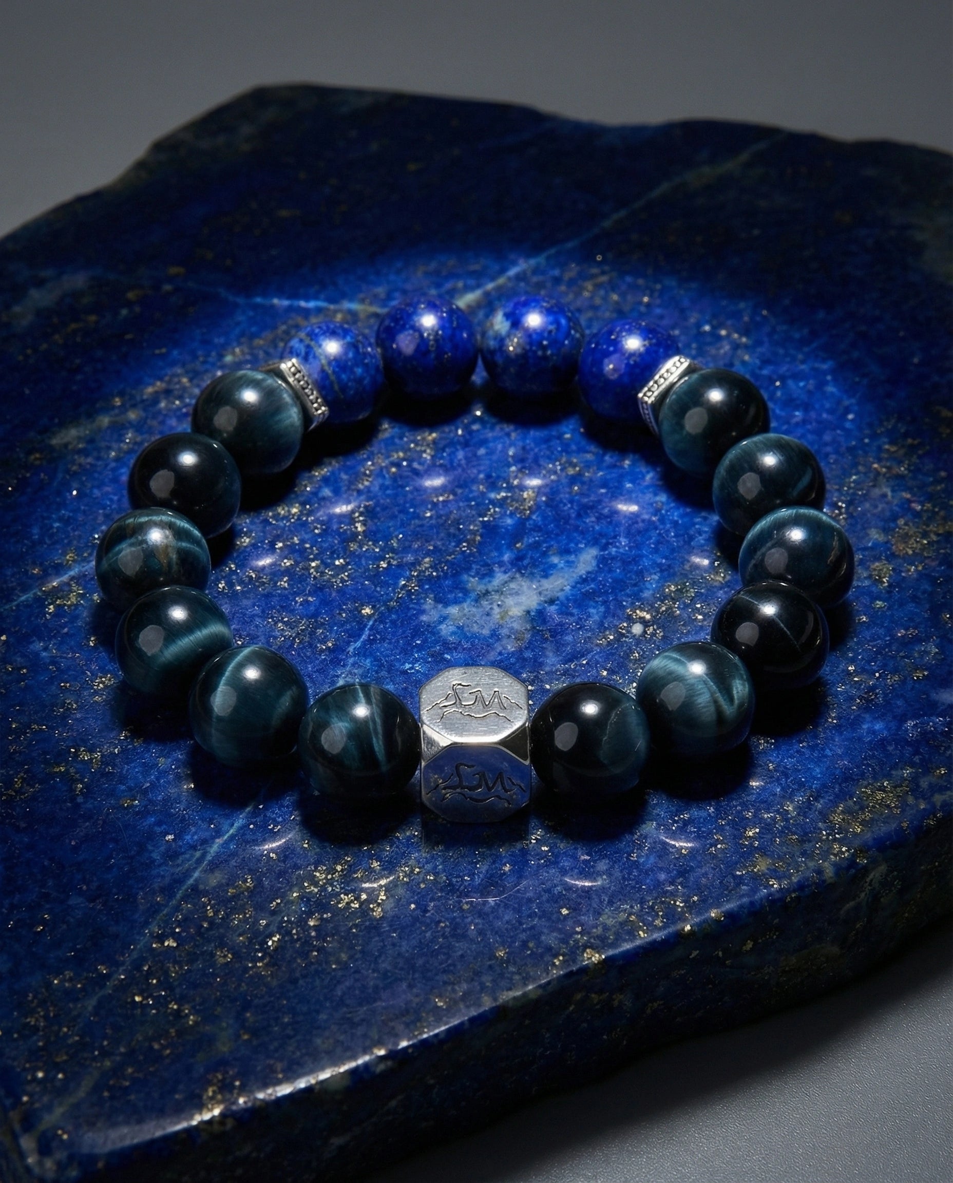 Oracle water crystal bracelet — lapis lazuli and blue tiger's eye — on raw lapis lazuli slab with gold pyrite veining — Leymen Jewels
