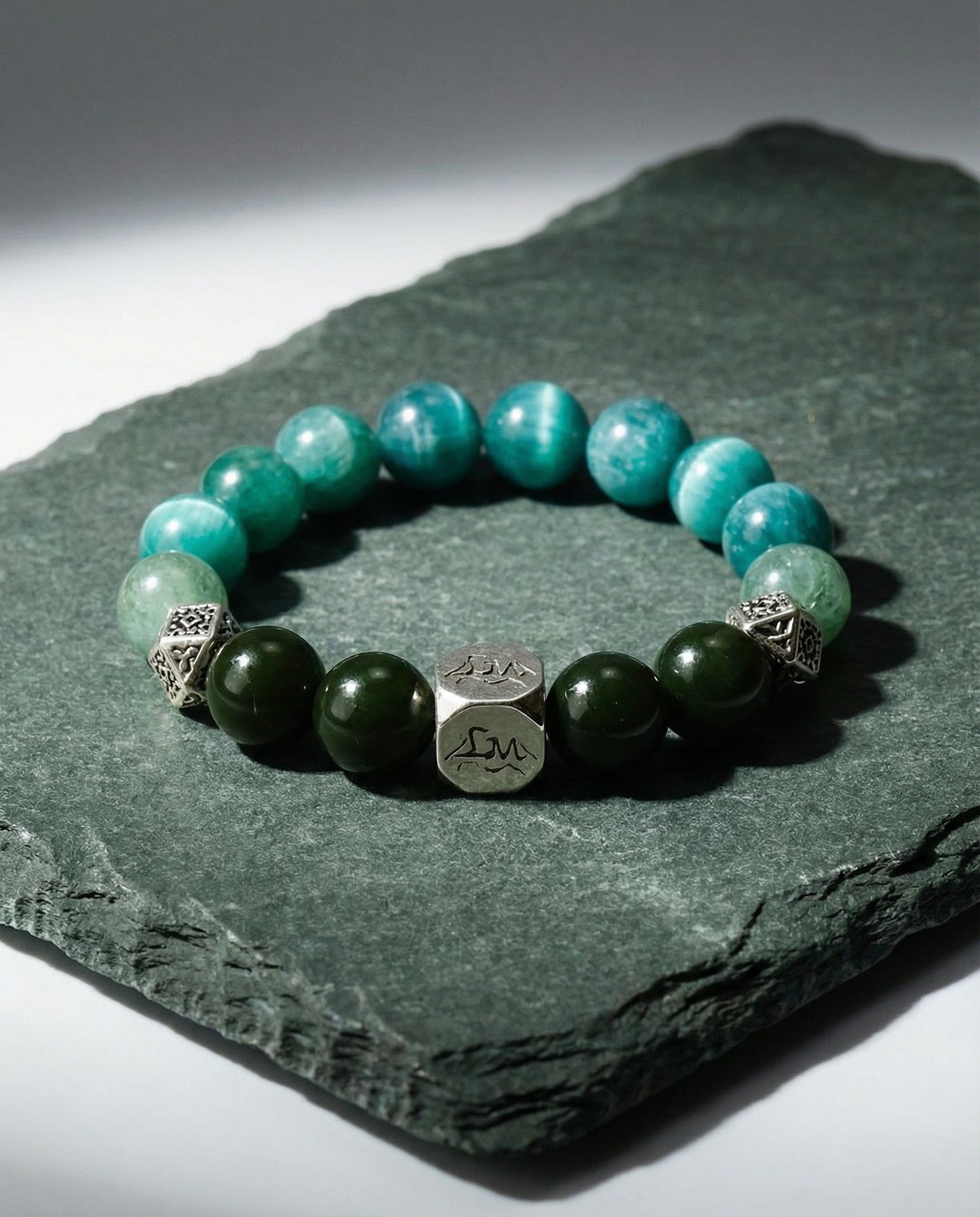 Orion wood crystal bracelet — teal kyanite and nephrite jade — on dark green slate stone surface — Leymen Jewels