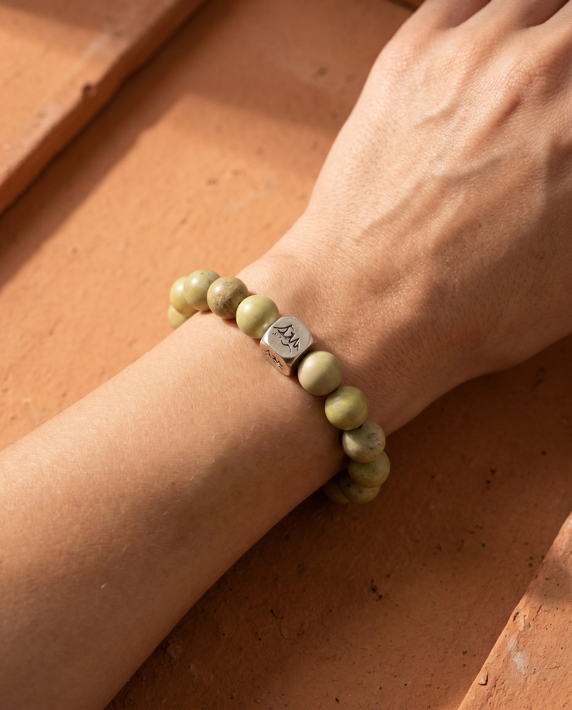 Sentinel earth crystal bracelet — blue pyrophyllite — worn on wrist against terracotta tile surface — Leymen Jewels