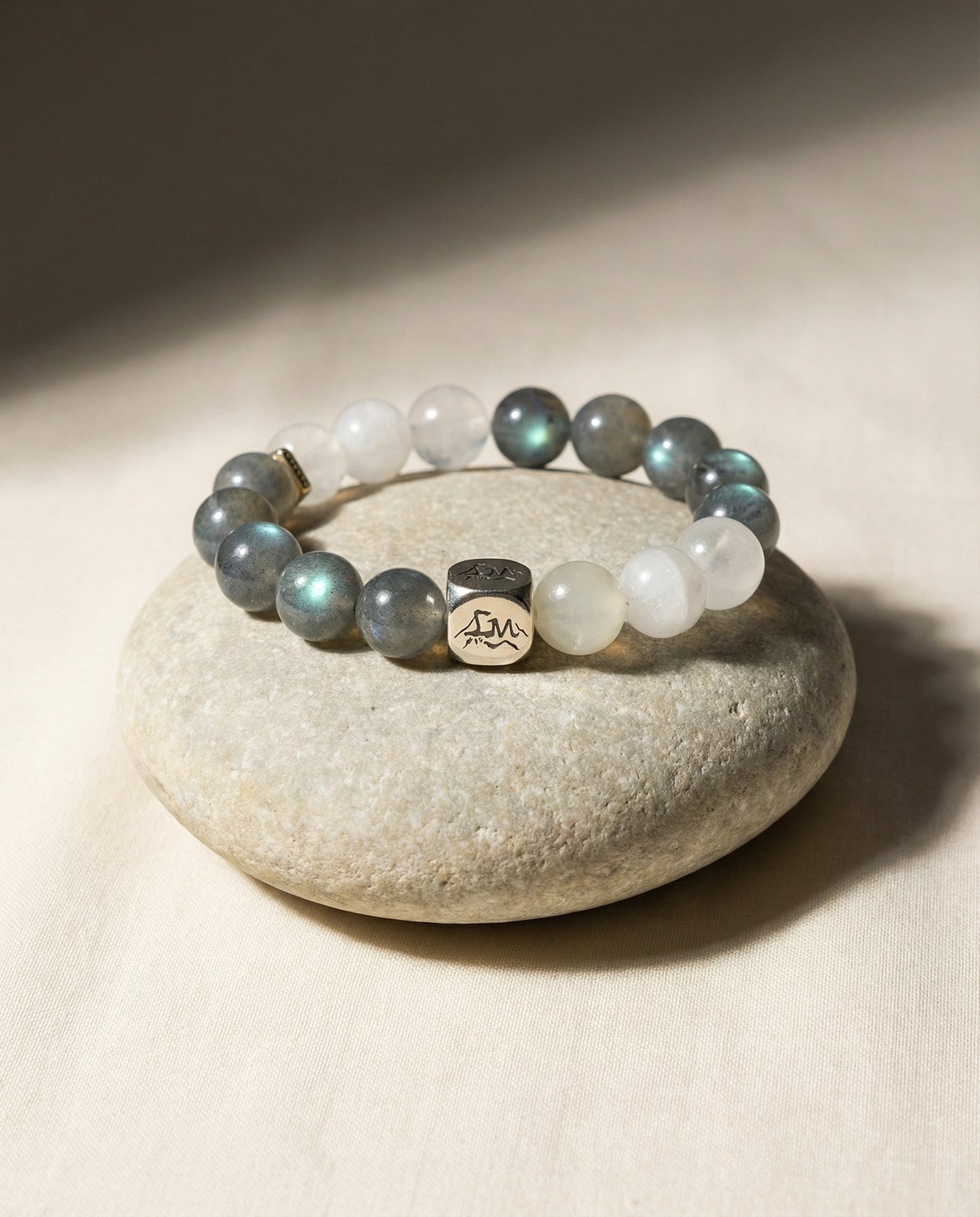 Threshold metal crystal bracelet — grey moonstone snow quartz and garnierite — on smooth river stone and linen — Leymen Jewels