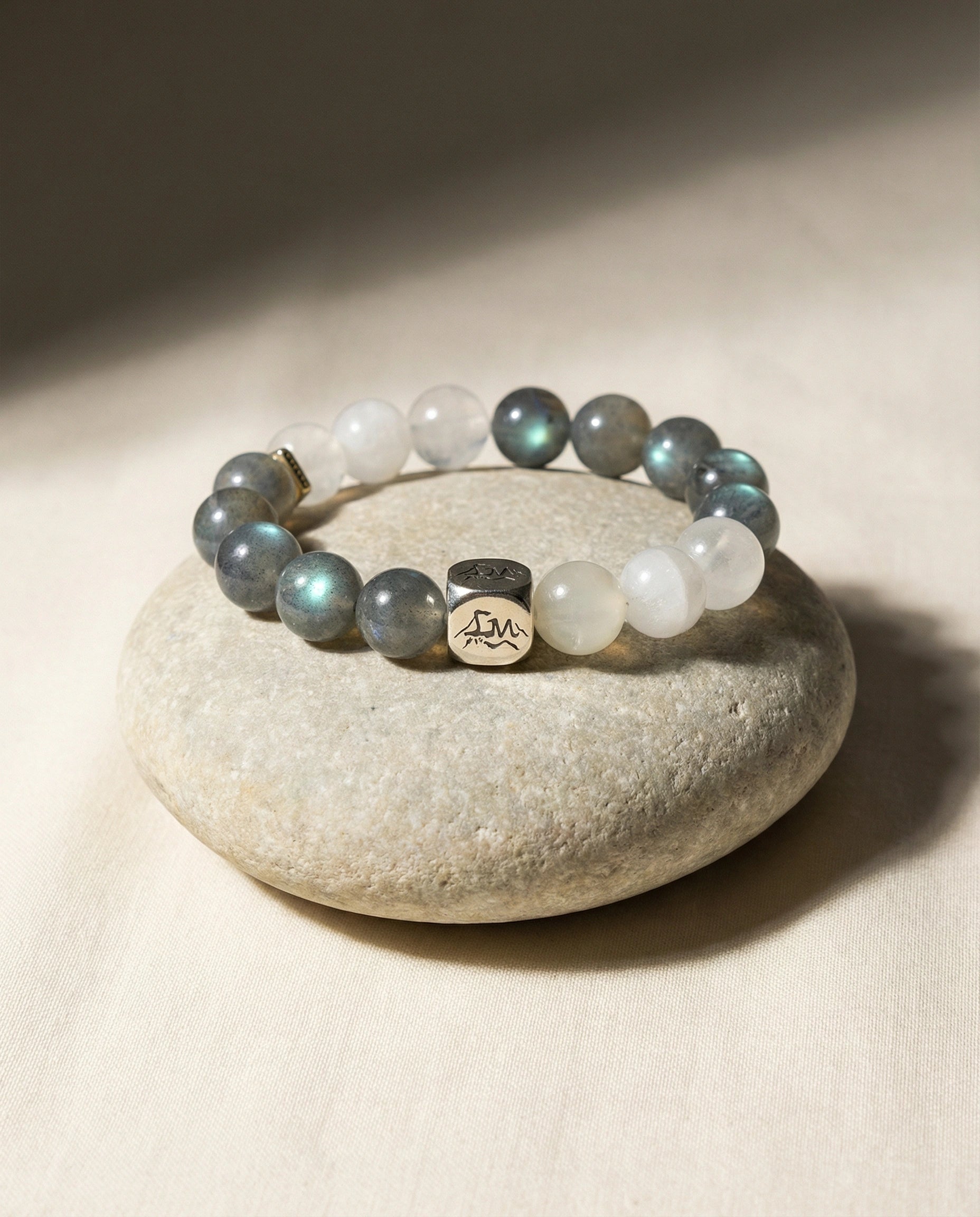 Threshold metal crystal bracelet — grey moonstone snow quartz and garnierite — on smooth river stone and linen — Leymen Jewels