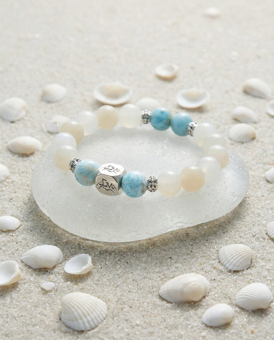 Tideborne water crystal bracelet — larimar and garnierite — on sea glass with white sand and shells — Leymen Jewels