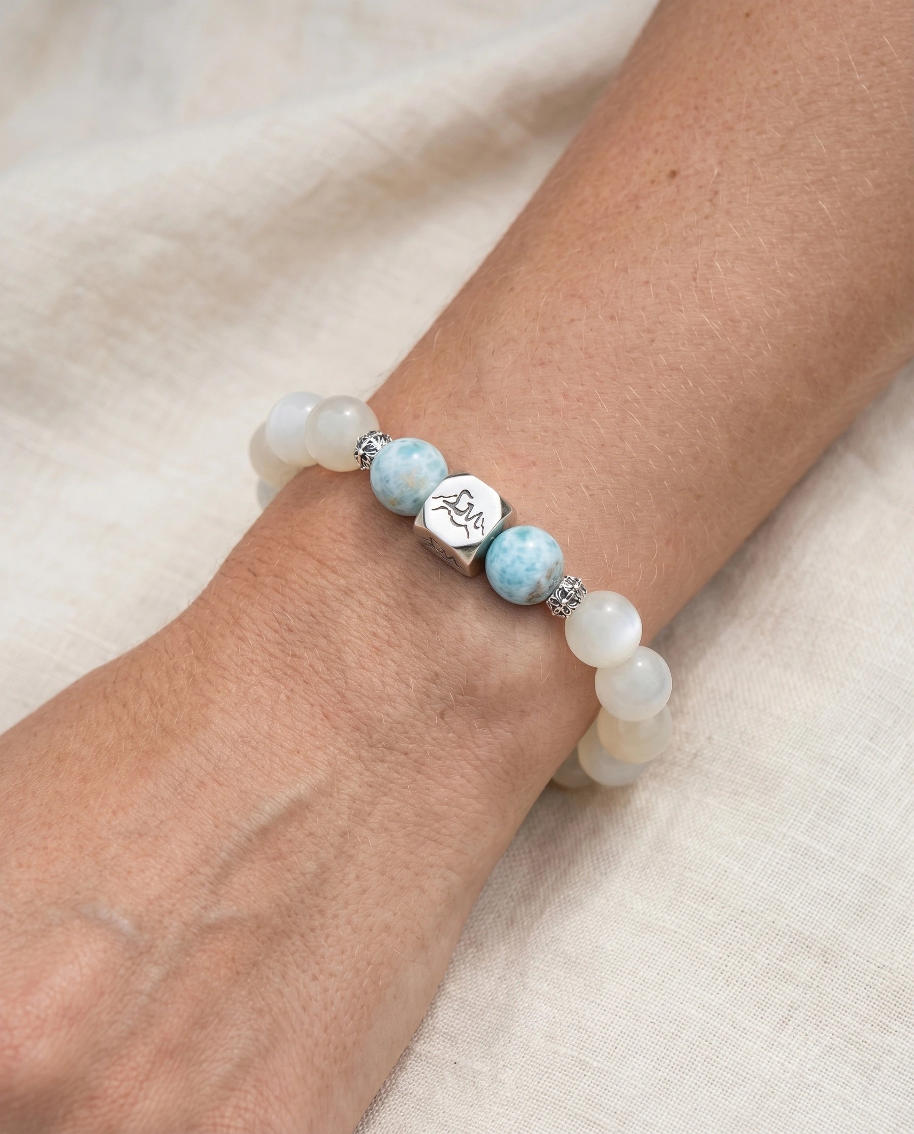 Tideborne water crystal bracelet — larimar and garnierite — worn on wrist against white linen fabric — Leymen Jewels