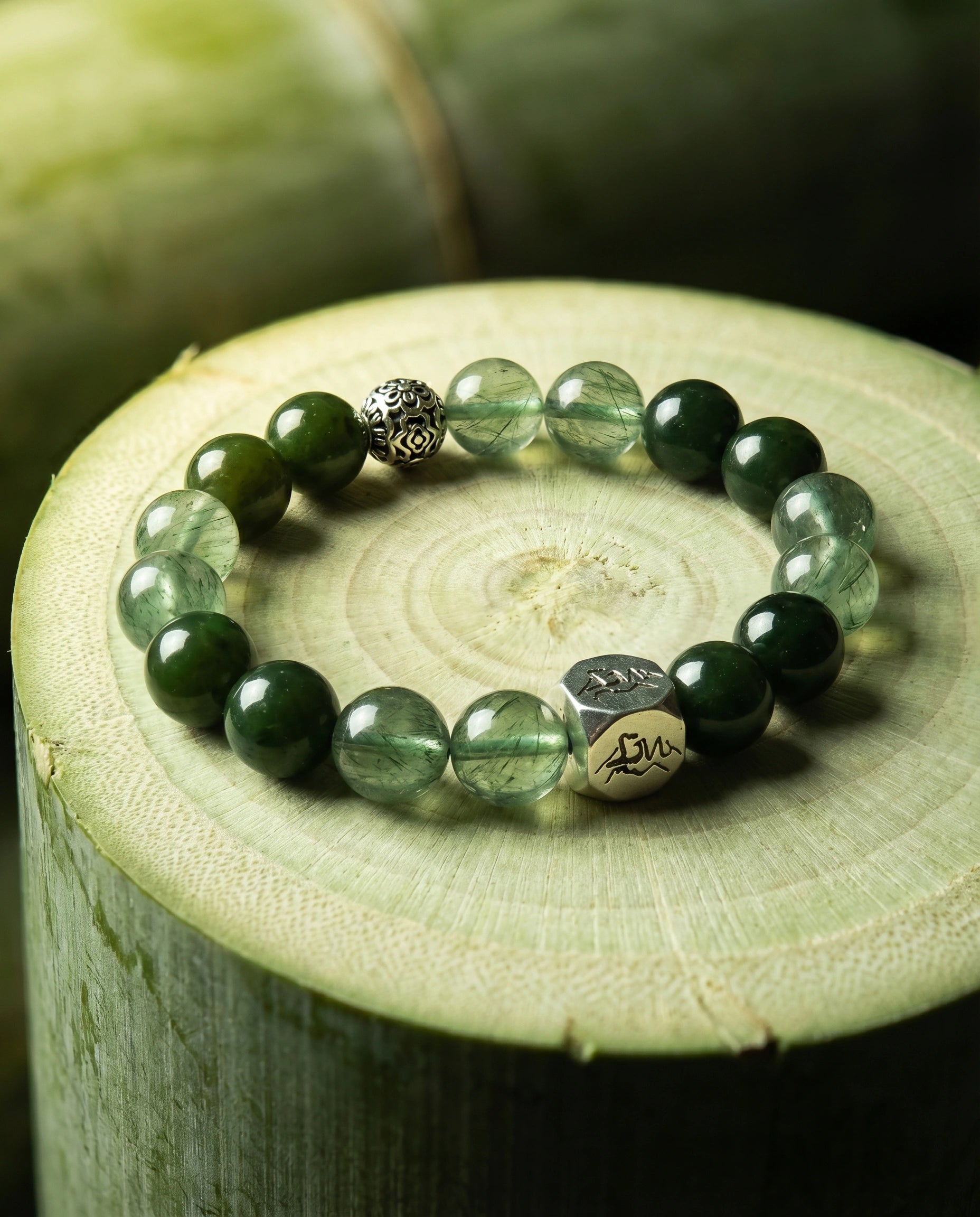 Verdant wood crystal bracelet — nephrite jade and green rutilated quartz — on fresh-cut bamboo with lush green foliage — Leymen Jewels